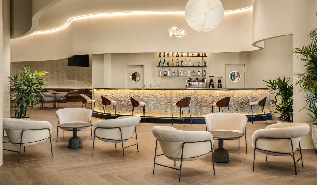 Bar moderno e arredato a Playa de las Américas, Tenerife, con sedie e piante.