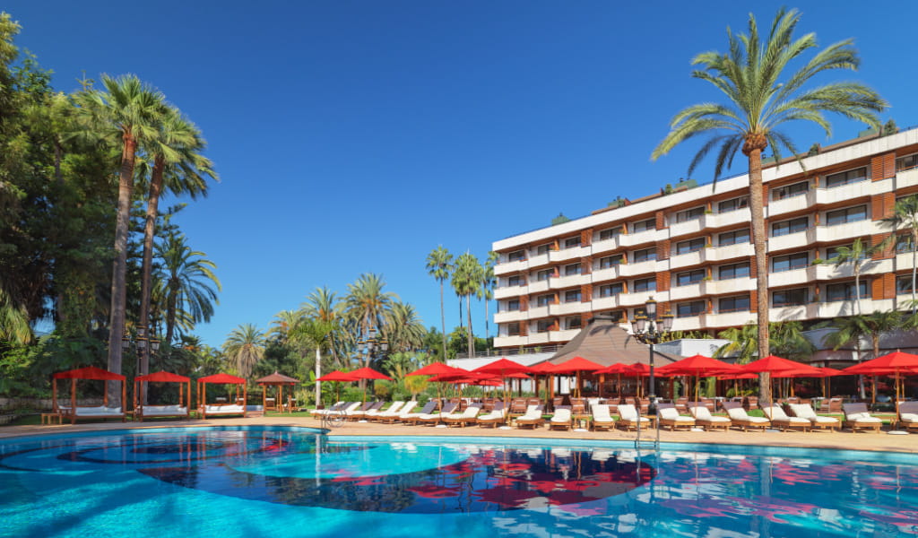 Edificio di hotel con piscina e palme a Puerto de la Cruz, Tenerife.