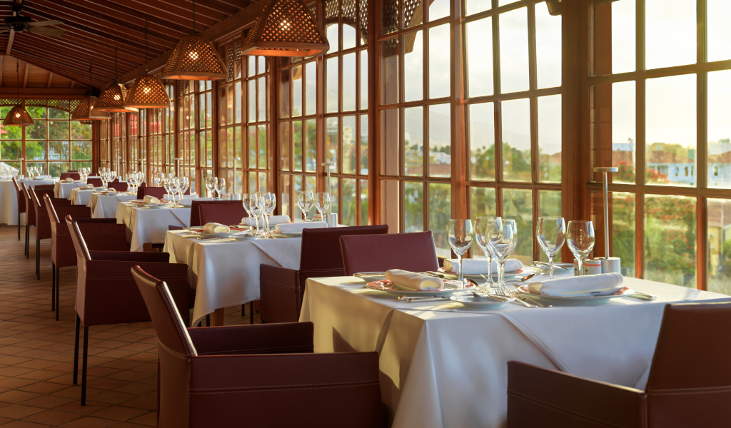 Ristorante elegante con tavoli apparecchiati e vista su Puerto de la Cruz, Tenerife.