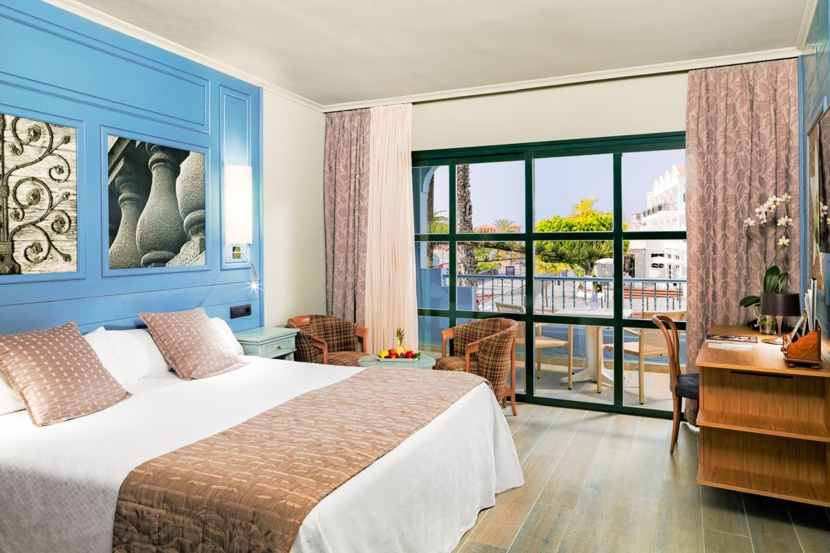Camera d'albergo a Playa de las Américas con grandi finestre e decorazioni blu.