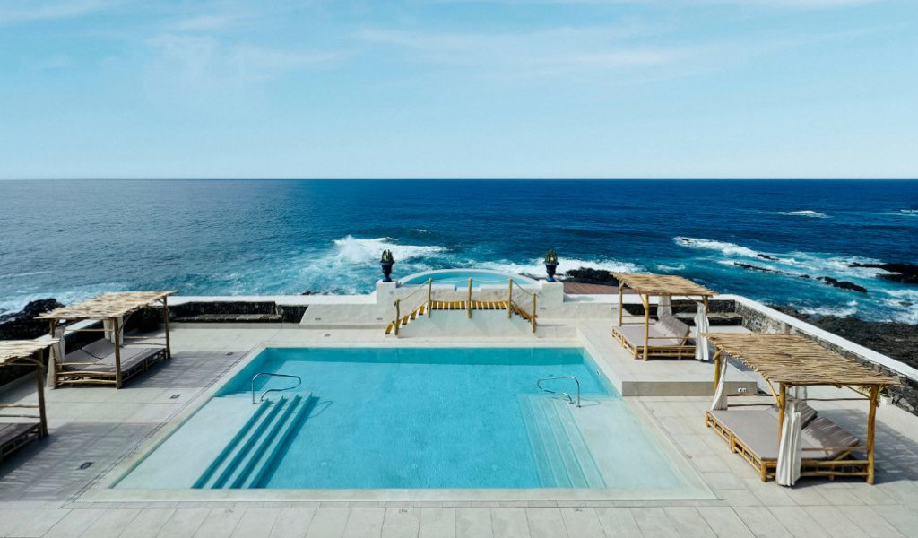 Piscina fronte mare a Garachico, Tenerife, con lettini e onde sullo sfondo.