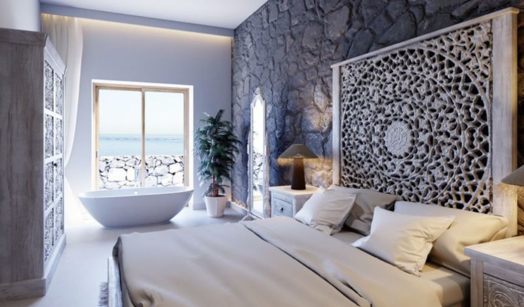 Camera da letto con vista mare a Tenerife, letto matrimoniale, vasca e decorazioni in rilievo.