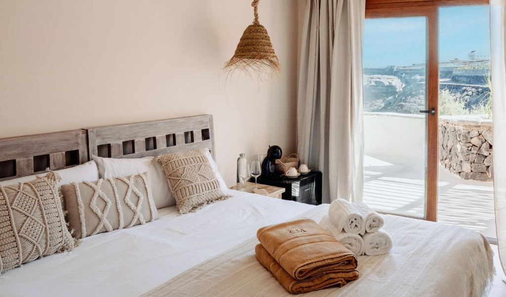 Camera da letto con cuscini decorativi e vista su Tenerife.