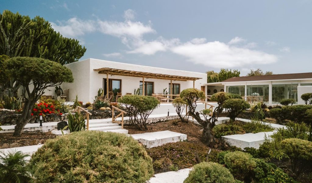Casa bianca con giardino di cactus a Tenerife sotto un cielo azzurro.