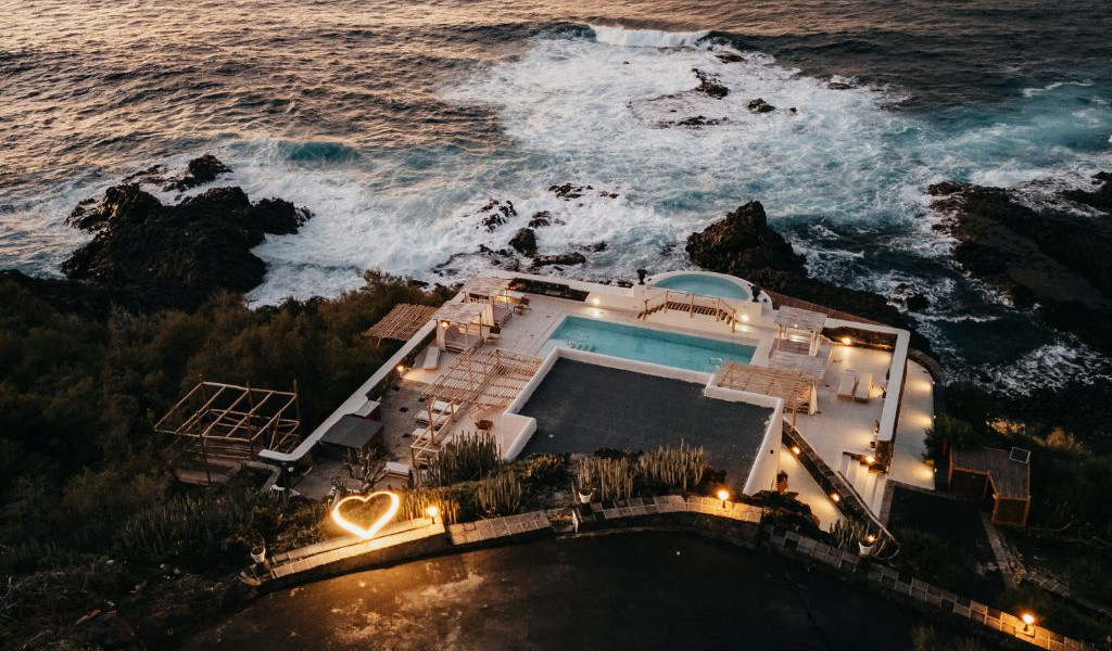 Vista aerea di una terrazza con piscina e mare a Tenerife, cuore luminoso sul pavimento.