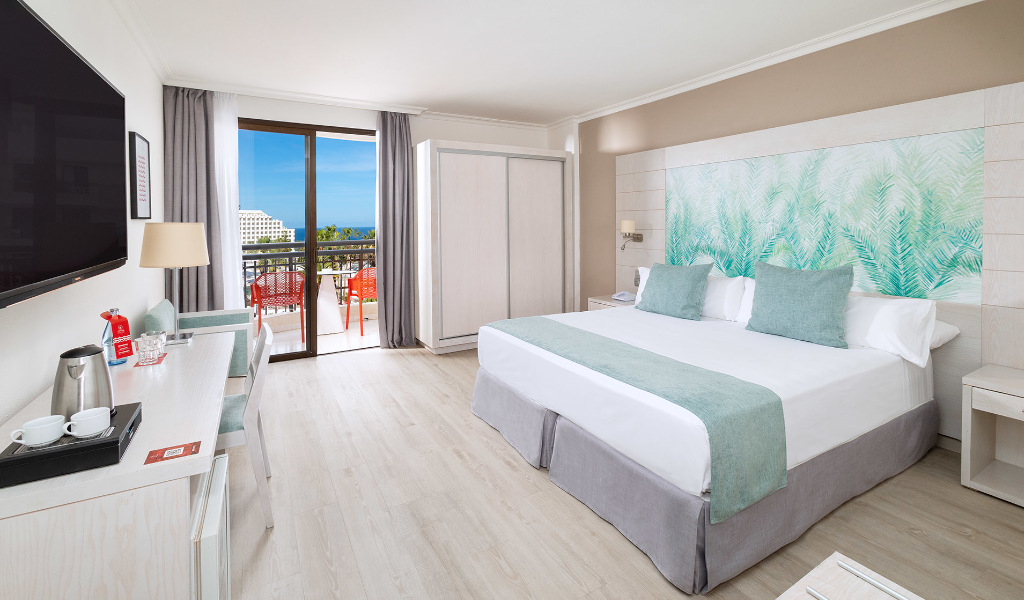 Camera moderna con letto matrimoniale, terrazza con vista sull'oceano a Tenerife.