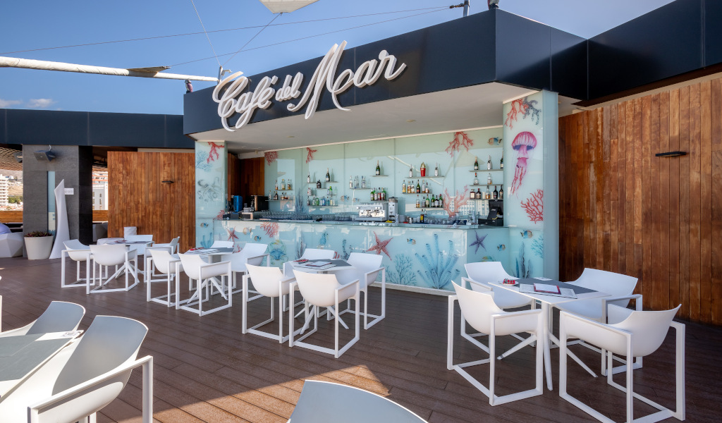 Bar all'aperto Café del Mar a Tenerife con tavoli e sedie bianche.