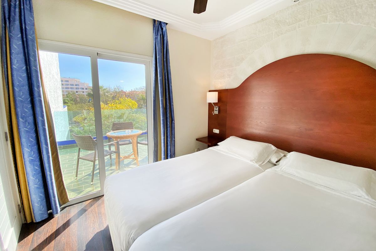 Camera da letto con due letti e balcone con tavolo a Puerto de la Cruz, Tenerife.