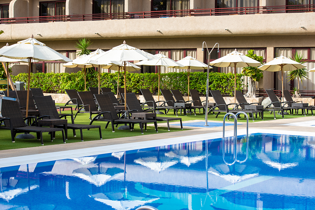 Sedie a sdraio e ombrelloni vicino alla piscina in un resort a Tenerife.