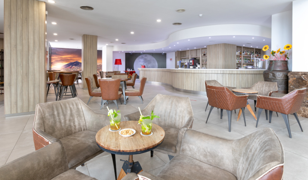 Bar contemporaneo con tavoli e sedie, bevande, e snack a Tenerife.