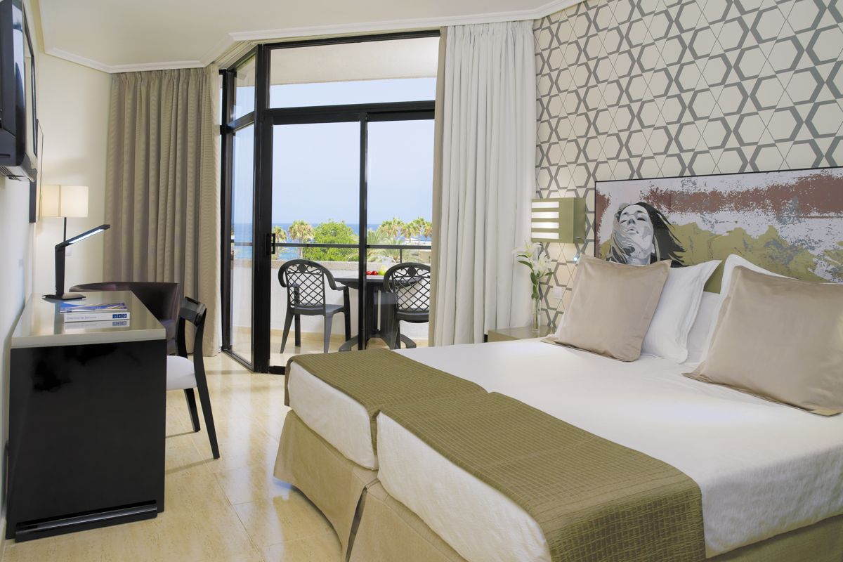 Camera da letto in hotel a Tenerife con balcone vista mare.