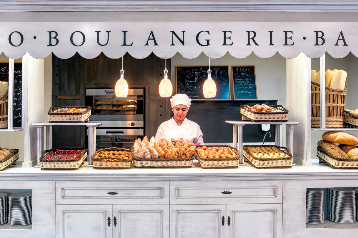 Panettiere che sistema prodotti da forno dietro il bancone a Puerto de la Cruz.