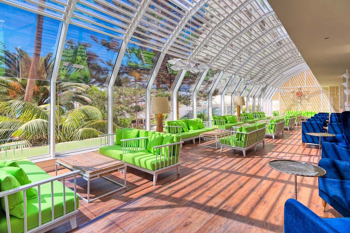 Sala luminosa con sedie verdi e divani blu a Santa Cruz de Tenerife.
