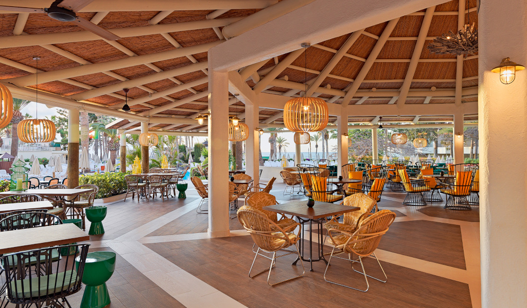 Ristorante all'aperto con sedie e tavoli, palme visibili. Località: Tenerife.