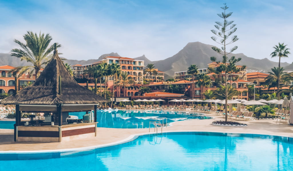 Piscina di un resort a Tenerife con montagne sullo sfondo.