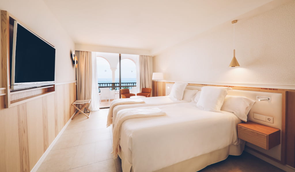 Camera d'albergo con due letti singoli e vista sul balcone a Tenerife.
