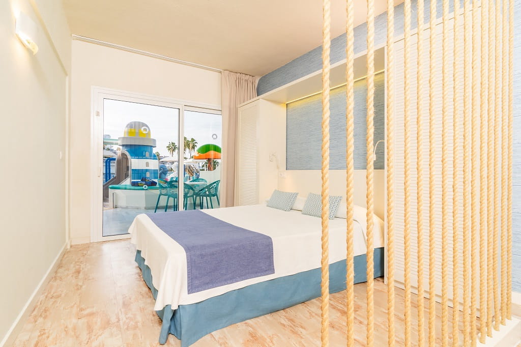 Camera d'albergo con letto matrimoniale e vista su parco giochi a Tenerife.