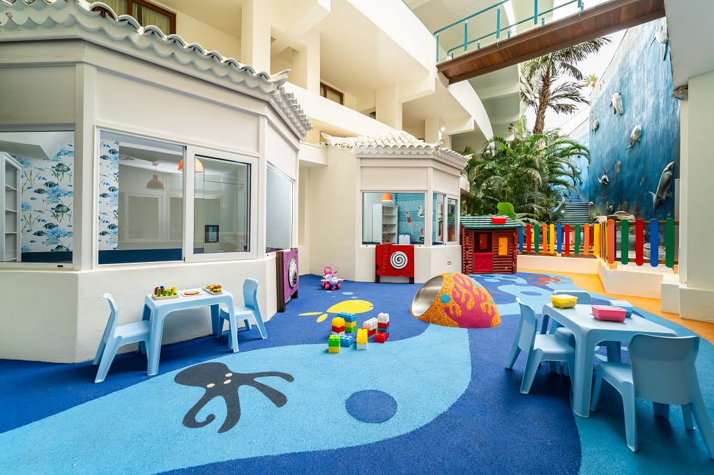 Area giochi per bambini con tavolini e sedie blu a Tenerife.