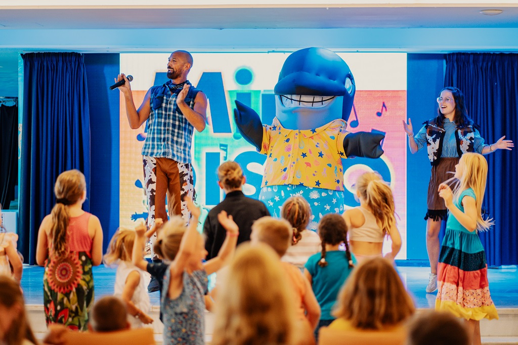 Personaggio di delfino e animatori intrattengono bambini a Costa Adeje, Tenerife.