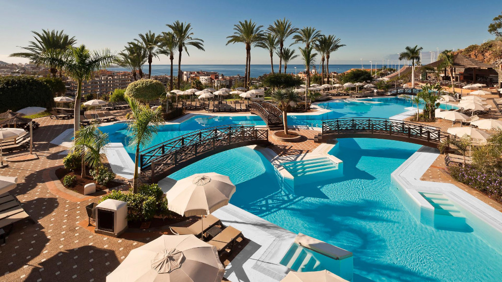 Piscina con palme e ponti in un resort di lusso a Tenerife.