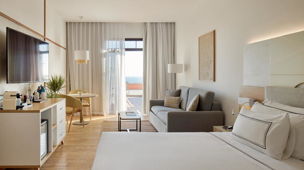 Camera d'albergo a Tenerife con letto, divano e vista sull'oceano.