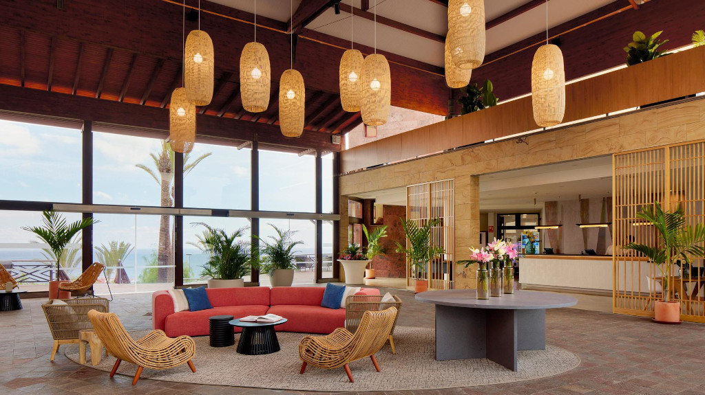 Lobby luminoso con sedie e divano rosso a Tenerife.