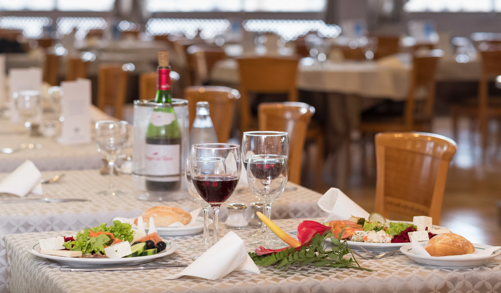 Tavola apparecchiata con piatti di insalate e vino in ristorante a Tenerife.