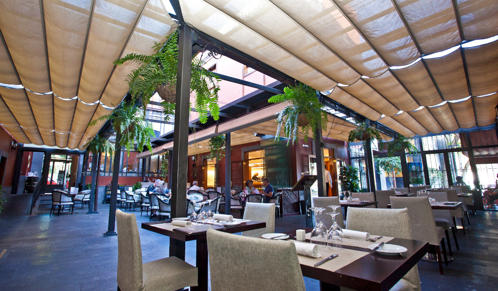 Ristorante a Tenerife con tavoli apparecchiati sotto un tetto coperto.