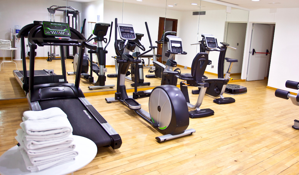Palestra con attrezzi fitness e specchi in un hotel a Tenerife.