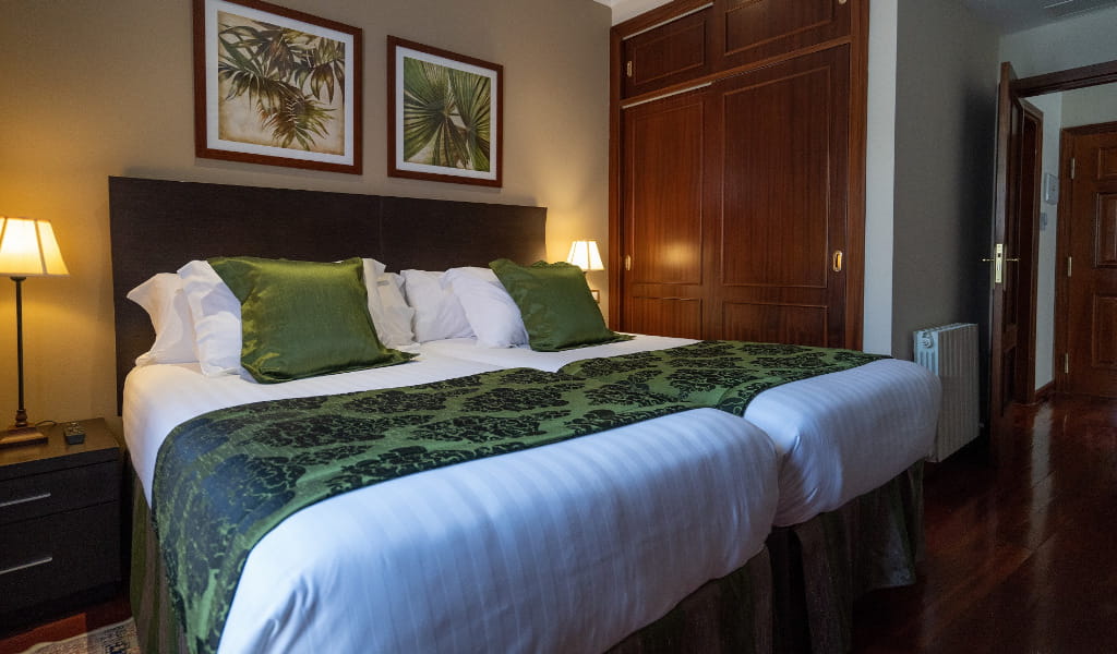 Camera d'albergo con letto matrimoniale e decorazioni verdi a Puerto de la Cruz.