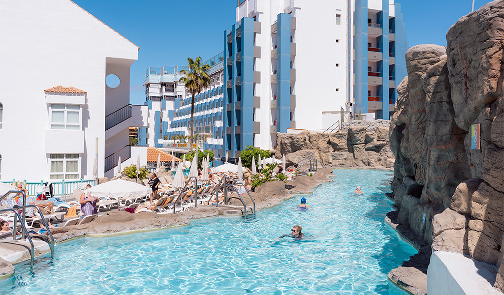 Piscina con rocce e persone che nuotano in un hotel a Tenerife.