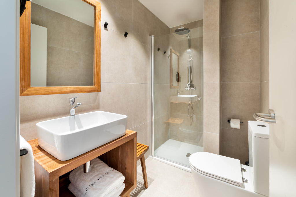 Bagno moderno con doccia, lavandino, specchio e asciugamano nell'hotel a Puerto de la Cruz.