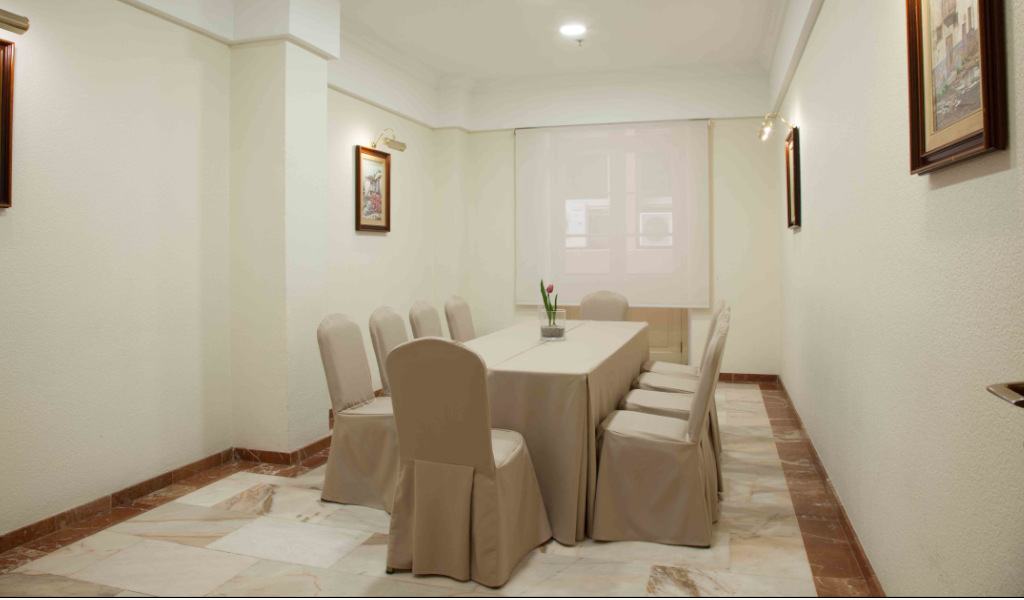 Sala riunioni con tavolo e sedie beige, decorata con quadri, a Tenerife.