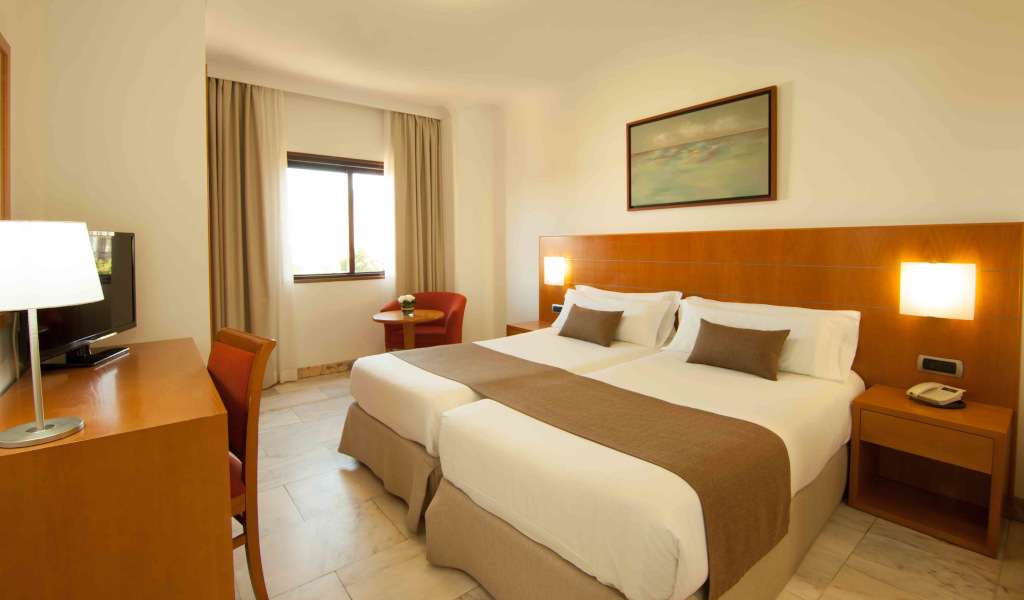 Camera d'hotel a Santa Cruz de Tenerife con due letti singoli e scrivania.
