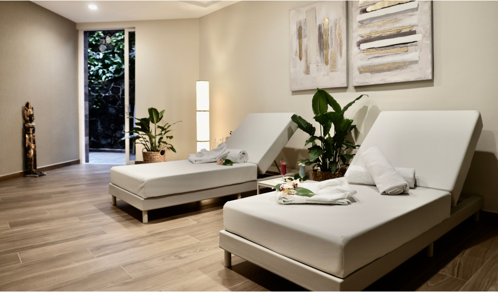 Lettini da massaggio in uno studio di benessere a Tenerife con piante e asciugamani.