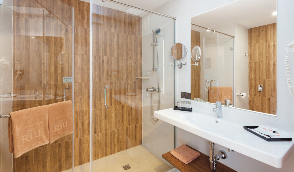 Bagno moderno con doccia, specchio e asciugamani dell'hotel Riu a Tenerife.