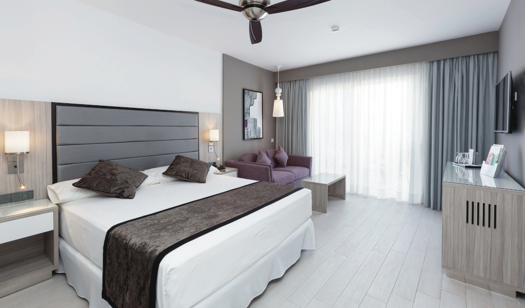 Camera da letto con letto matrimoniale e divano presso un hotel a Tenerife.
