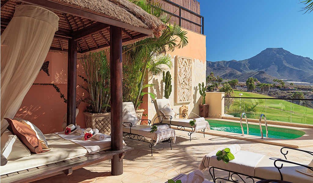 Terrazza con lettini, piscina e vista montagna a Tenerife.
