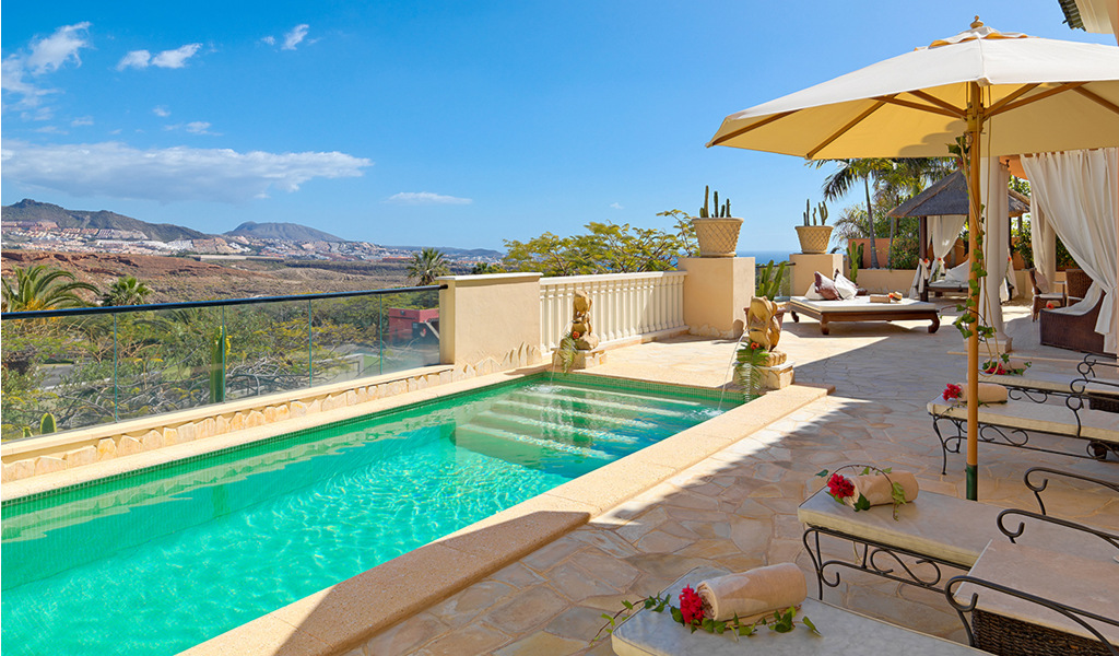 Piscina con lettini e ombrellone su una terrazza a Tenerife.