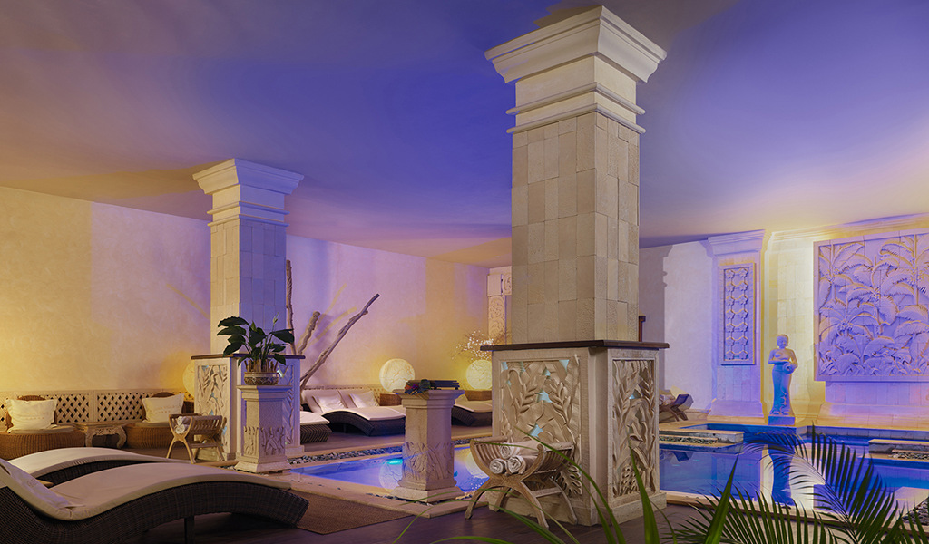 Sala relax con piscina e divani, decorata con colonne e sculture a Tenerife.