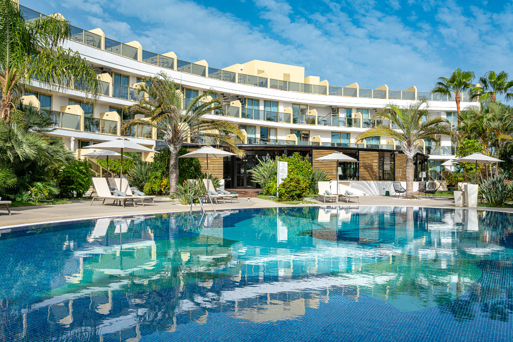 Edificio hotel con piscina e ombrelloni a Tenerife.