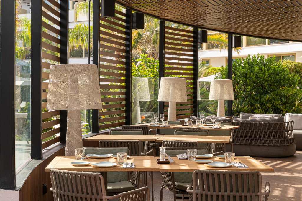 Tavoli apparecchiati in un ristorante a Tenerife con lampade decorative.