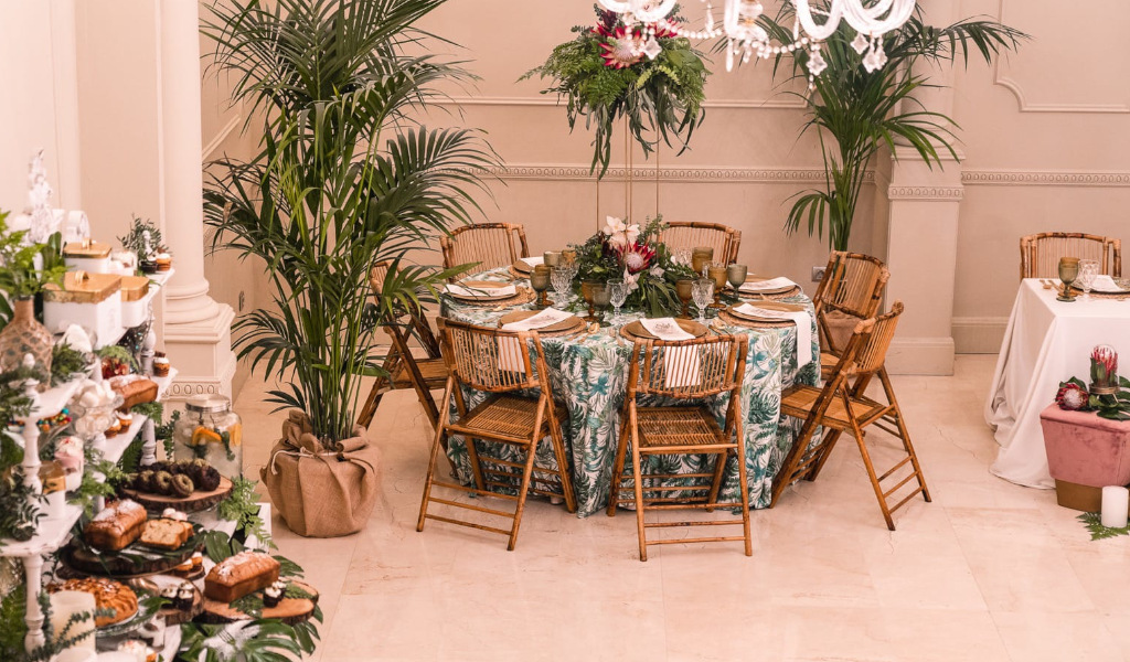 Tavola decorata con fiori e piatti, sedie di legno in un salone a Tenerife.