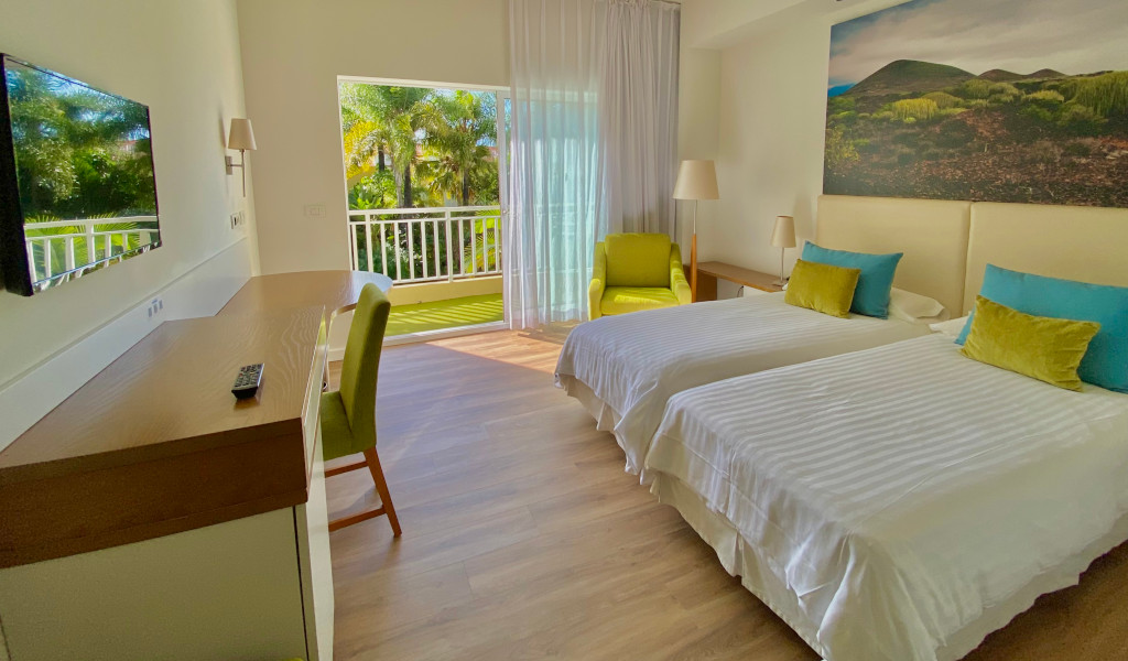 Camera d'albergo a Tenerife con letti singoli, scrivania e balcone.