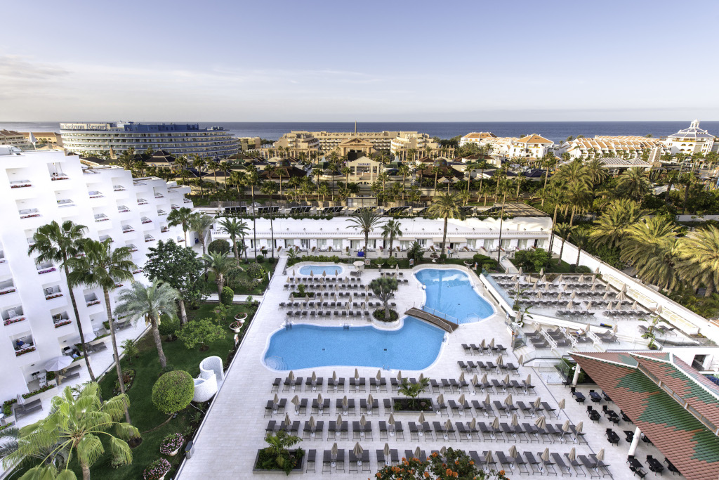 Vista del resort con piscina e giardino, sullo sfondo di Playa de las Américas, Tenerife.