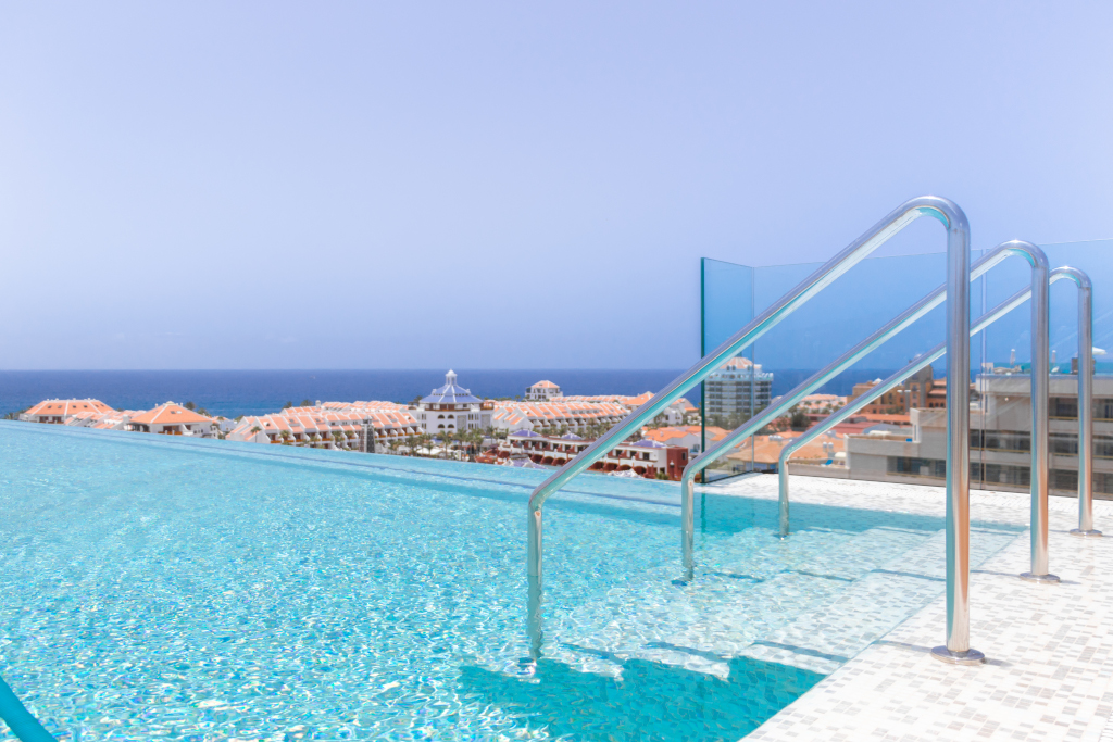 Piscina a sfioro con vista sull'oceano e Los Cristianos a Tenerife.