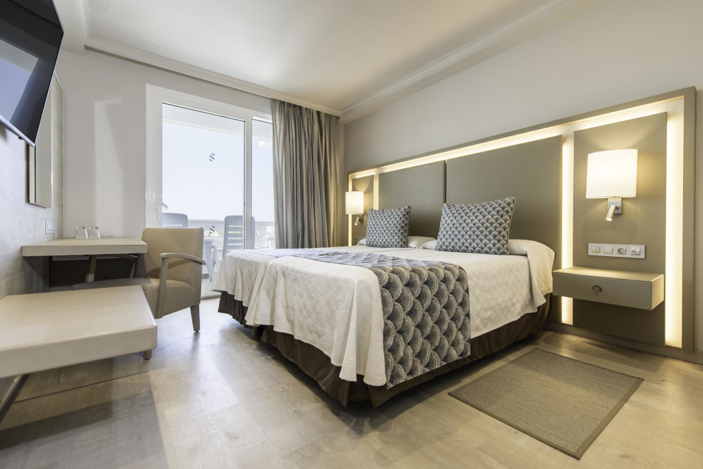 Camera d'albergo moderna con letto matrimoniale e luminosa finestra a Tenerife.