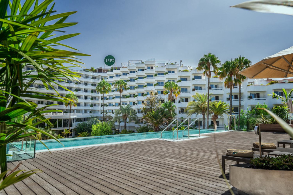 Piscina circondata da palme e edificio bianco a Tenerife.