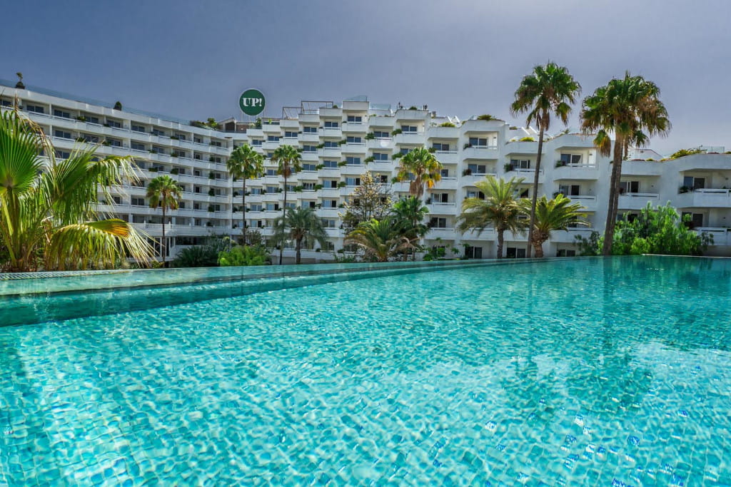 Piscina e palme davanti a un edificio bianco a Tenerife.