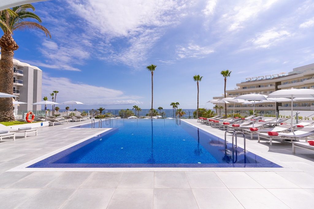Piscina all'aperto con lettini e ombrelloni a Costa Adeje, Tenerife.